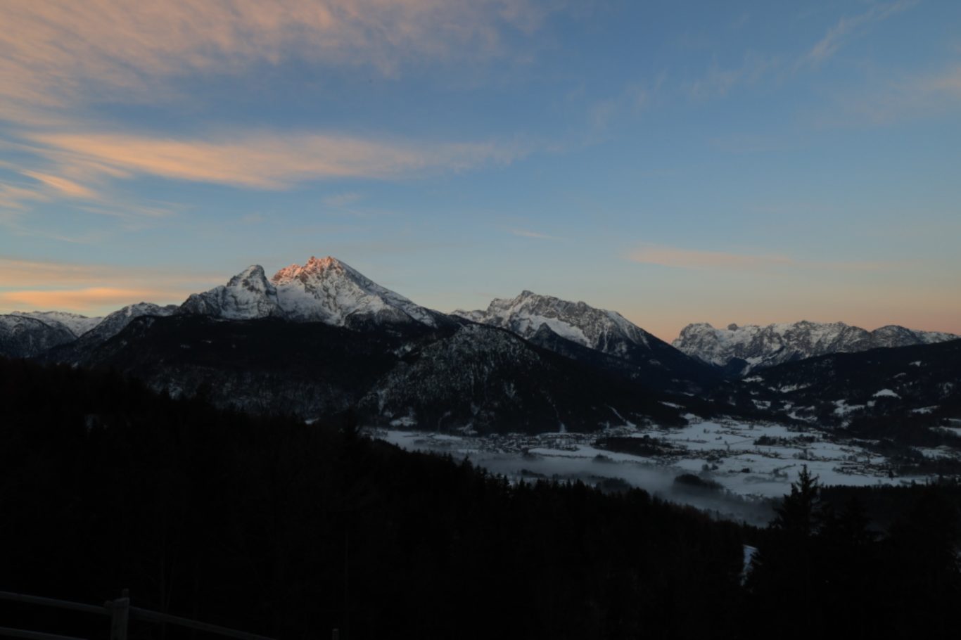 Blick zum Watzmann Berglandschaft mit schneebedeckten Gipfeln und sanften Hügeln bei Sonnenaufgang.